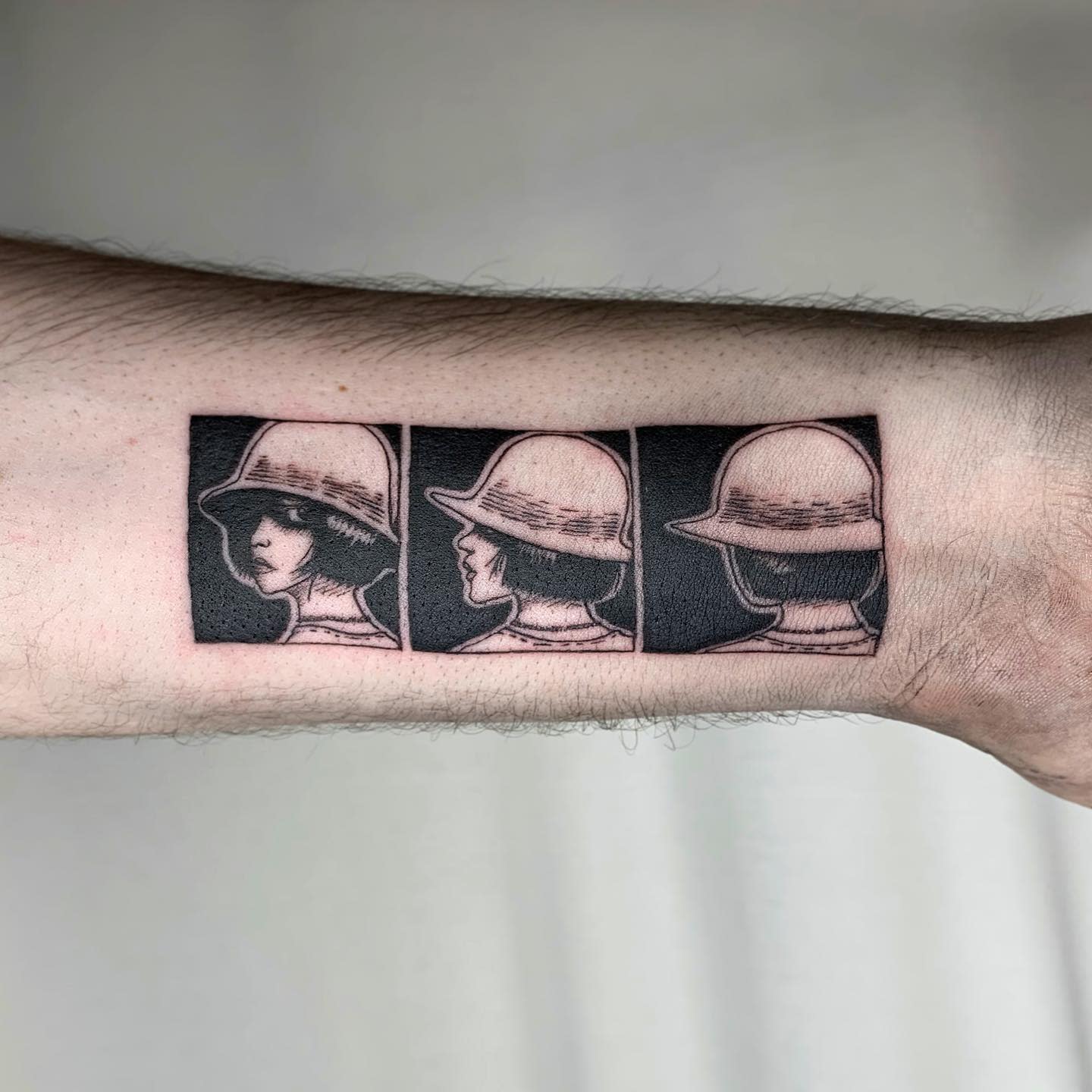 Forearm tattoo showing three sequential panels of a Junji Ito character turning their head