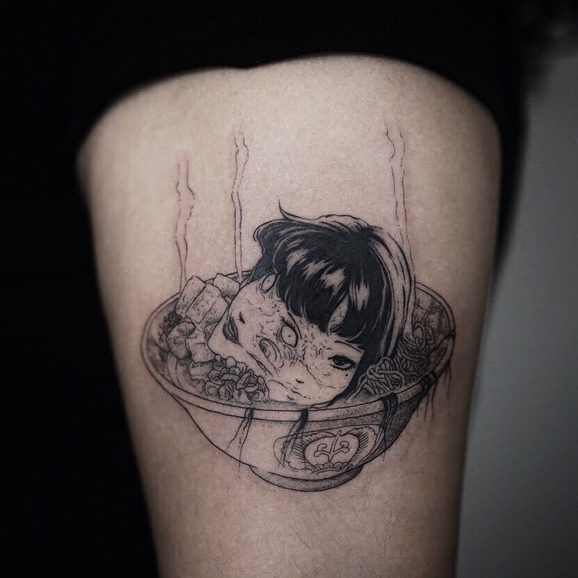Thigh tattoo of a Junji Ito character's head floating in a bowl of ramen, blending horror with dark humor