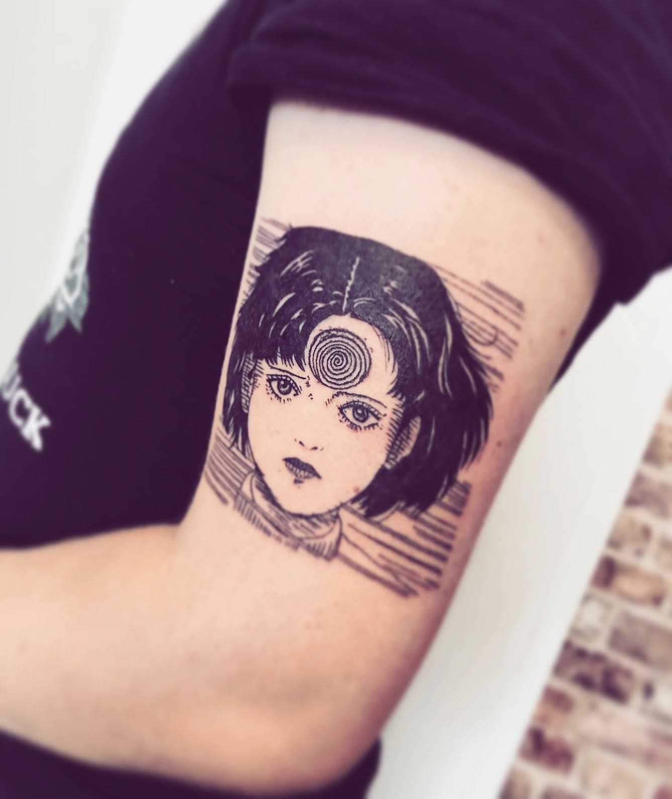 Junji Ito-inspired tattoo of a character with a spiral on her forehead, capturing the 'Uzumaki' horror theme