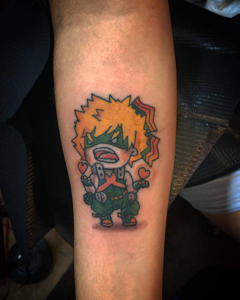 Chibi-style tattoo of Katsuki Bakugo from My Hero Academia, looking angry yet adorable, with small hearts and comic-style explosion effects