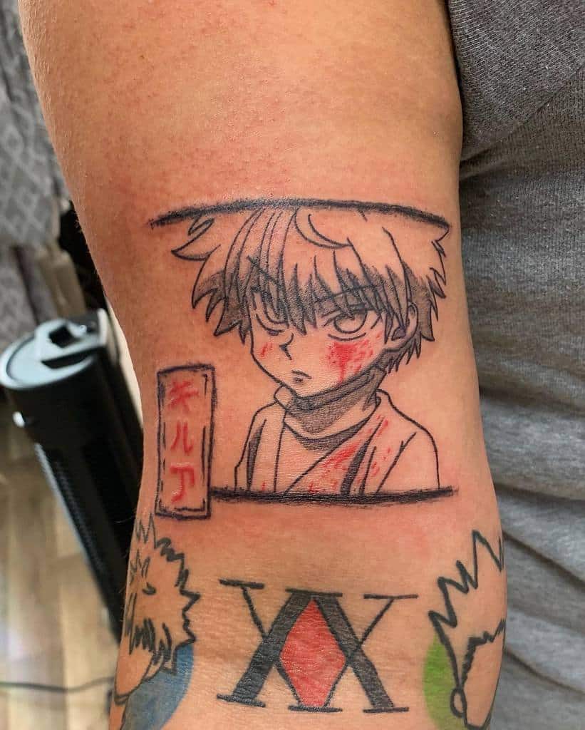 Killua Zoldyck tattoo from Hunter X Hunter, featuring his intense gaze, battle marks, and the addition of his name in Japanese characters