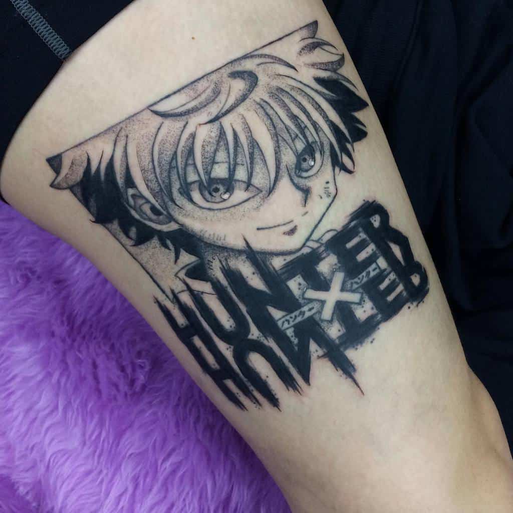 Black-and-white Killua Zoldyck tattoo from Hunter X Hunter, featuring his playful expression and the 'HUNTER X HUNTER' text incorporated into the design