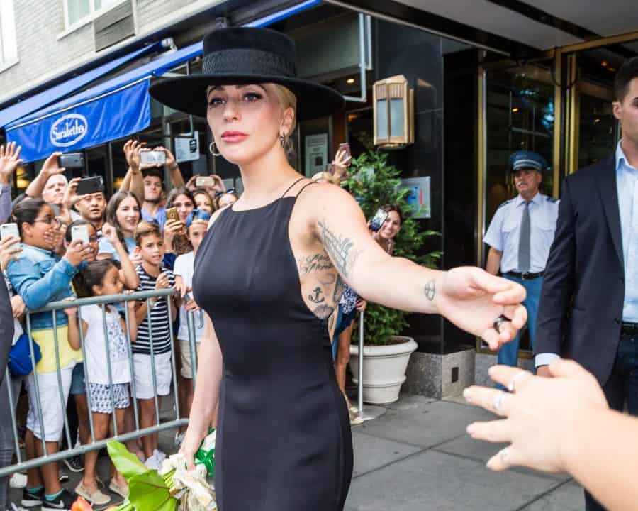 Lady Gaga's black ink tattoos, including an anchor, script text, and a small geometric design