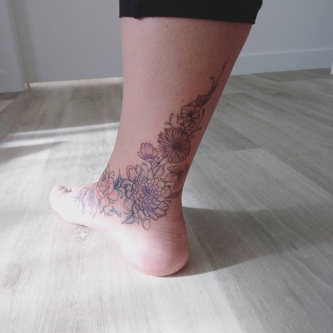 Ankle tattoo of floral design with larkspur on a leg