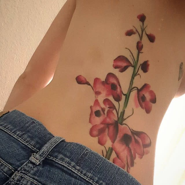 Large pink flower tattoo on someone's back