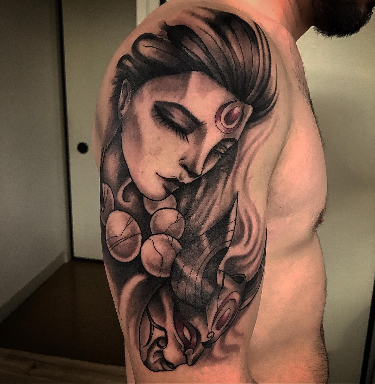 Black and grey tattoo of Diana from League of Legends on the shoulder, depicting her serene and focused expression with flowing hair and lunar symbols