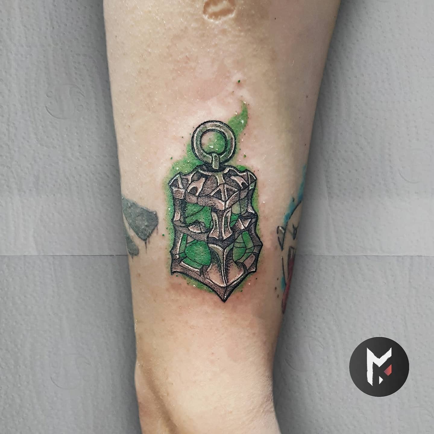 Small tattoo of Thresh's lantern from League of Legends, with glowing green accents on the forearm