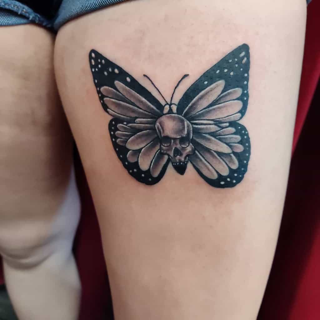 Tattoo of a butterfly with a skull on its wings on a thigh