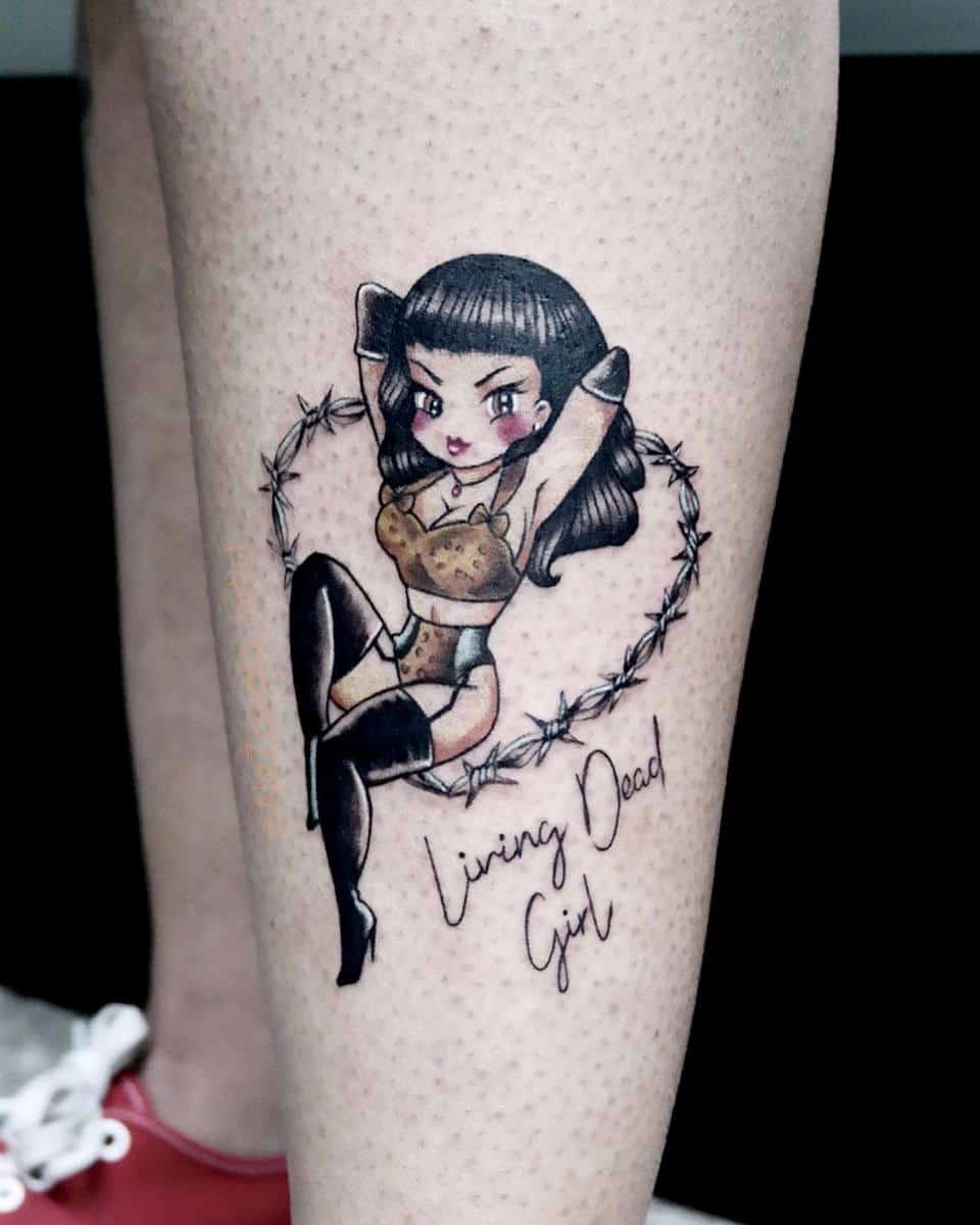 Tattoo of a pin-up style girl with black hair in lingerie, sitting in a barbed wire heart with "Living Dead Girl" text below