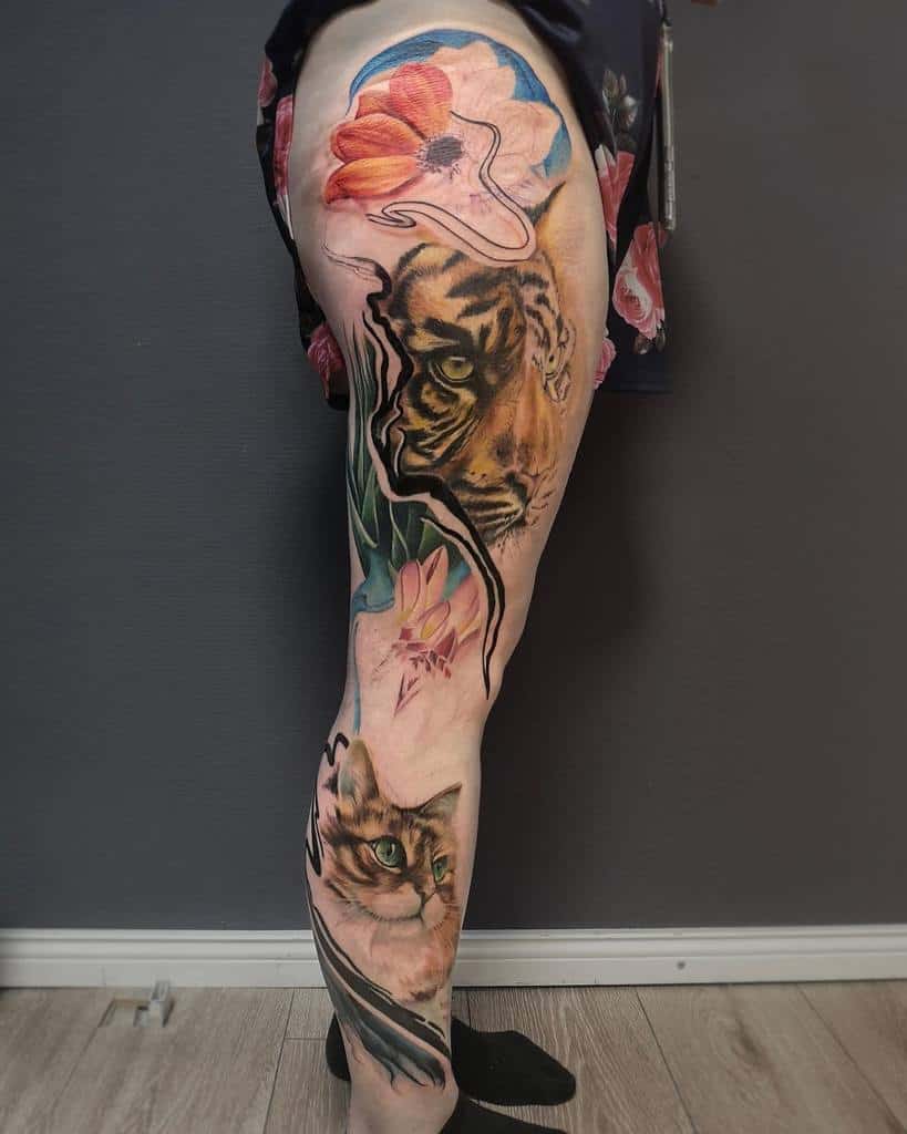 Leg tattoo featuring a tiger, a cat, and colorful flowers