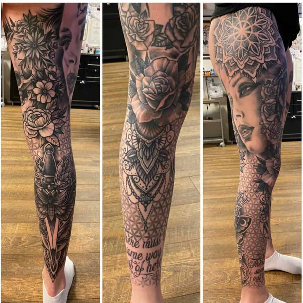 This intricate black-and-grey leg sleeve tattoo features a blend of floral patterns, a delicate mandala, and a striking portrait, seamlessly combining realism with ornamental elements for a captivating and harmonious design