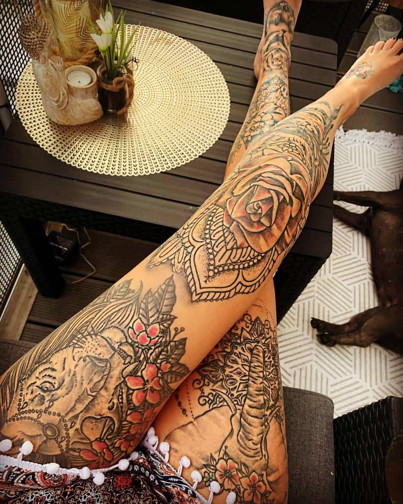 This stunning leg sleeve tattoo features a blend of intricate mandala designs, bold floral patterns, and an elephant motif, creating a harmonious and symbolic masterpiece that emphasizes both beauty and strength
