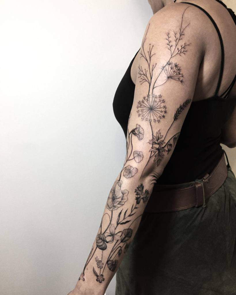 A beautiful linework floral tattoo sleeve featuring delicate botanical designs and intricate details
