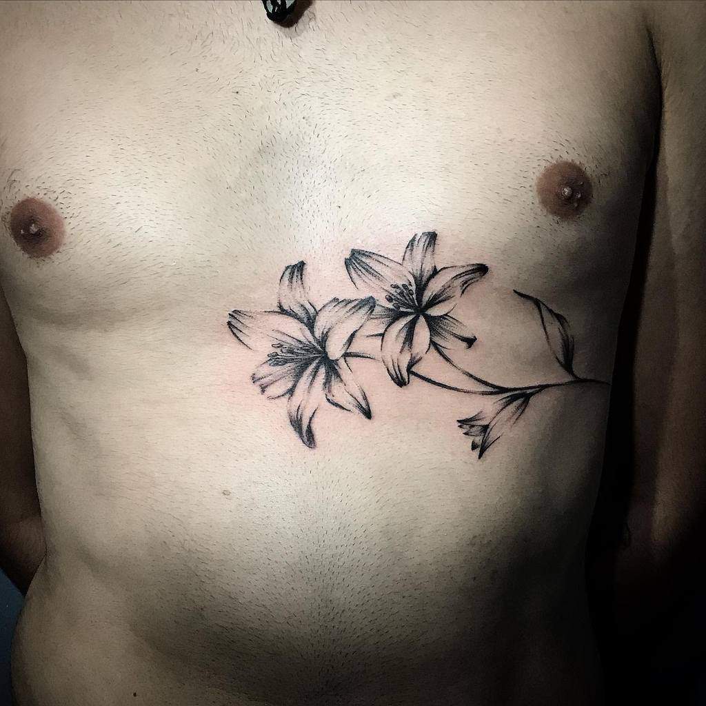 Elegant black and grey tattoo of two blooming lilies with soft shading and fine lines, symbolizing growth, beauty, and resilience