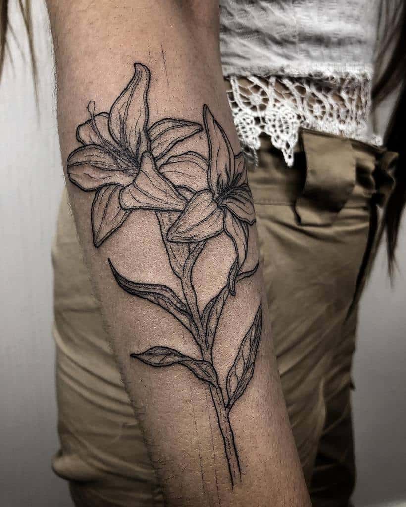 Elegant black and grey tattoo of two blooming lilies with fine linework and subtle shading