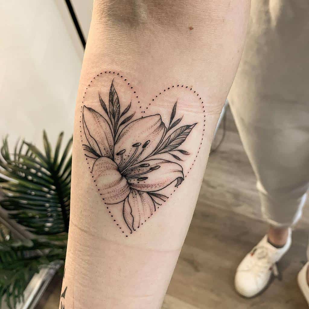 Delicate black and grey tattoo of a blooming lily framed by a dotted heart outline, symbolizing love, beauty, and personal meaning