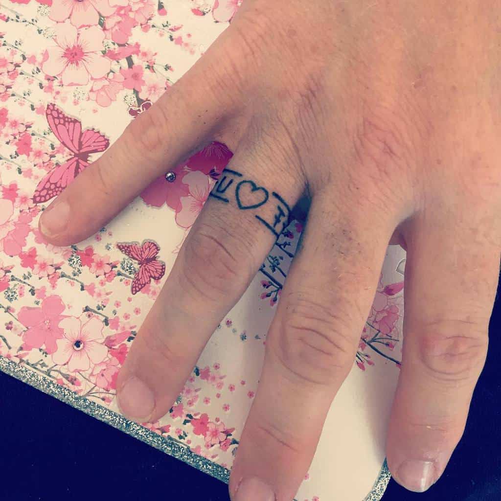 A simple and meaningful ring tattoo on the finger, reading "I ♥ F," where the heart symbolizes love