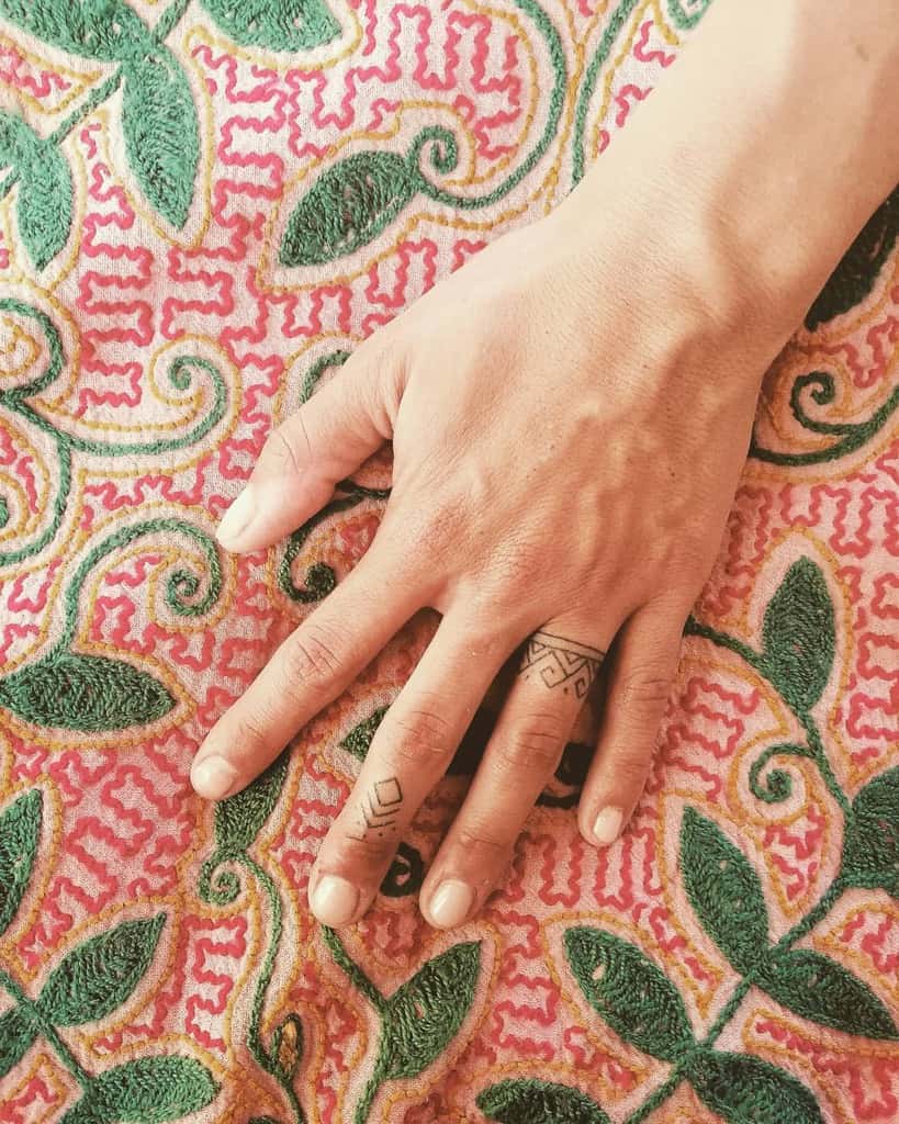 A set of intricate geometric ring tattoos, featuring clean lines and angular patterns