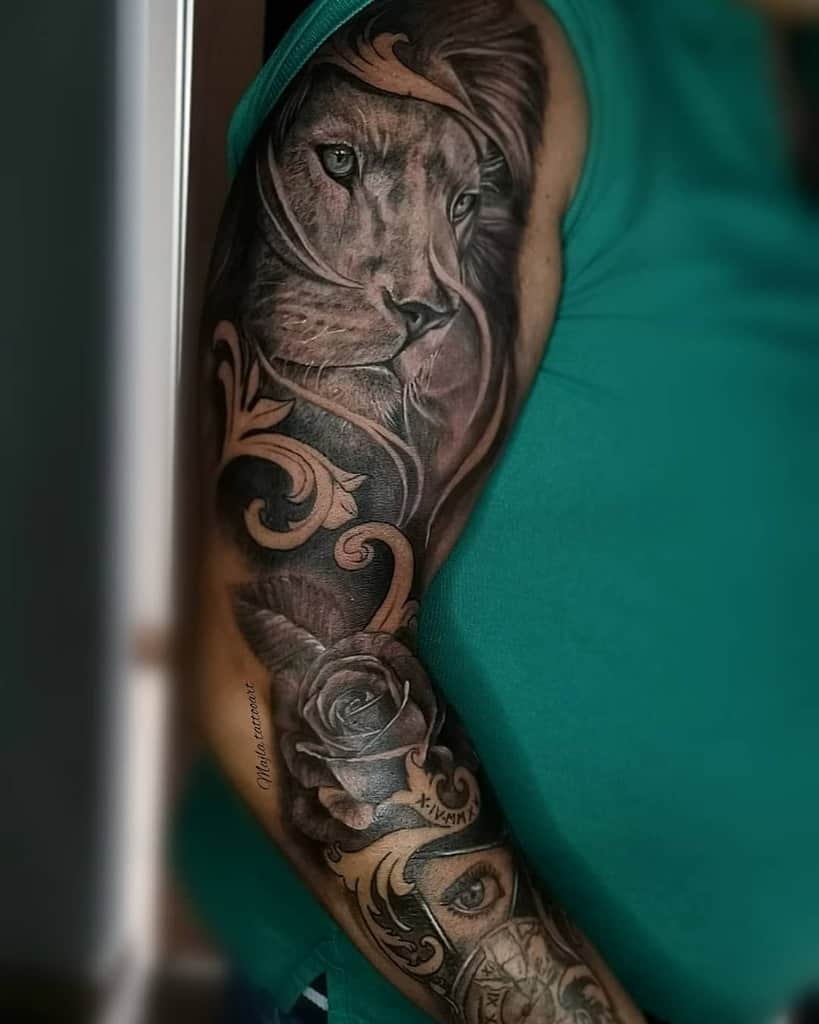 Arm tattoo of a lion, floral designs, and a rose