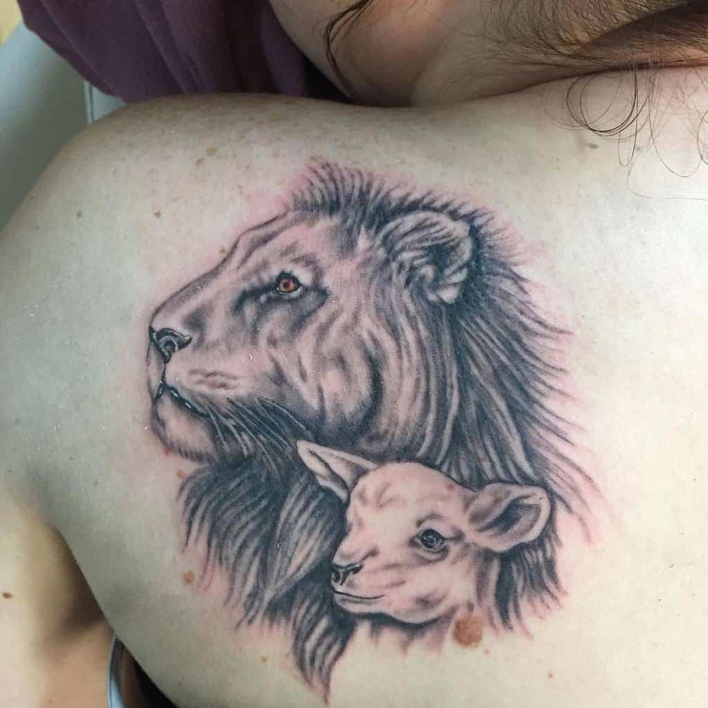 A stunning tattoo of a lion embracing a lamb adorns the person's upper back