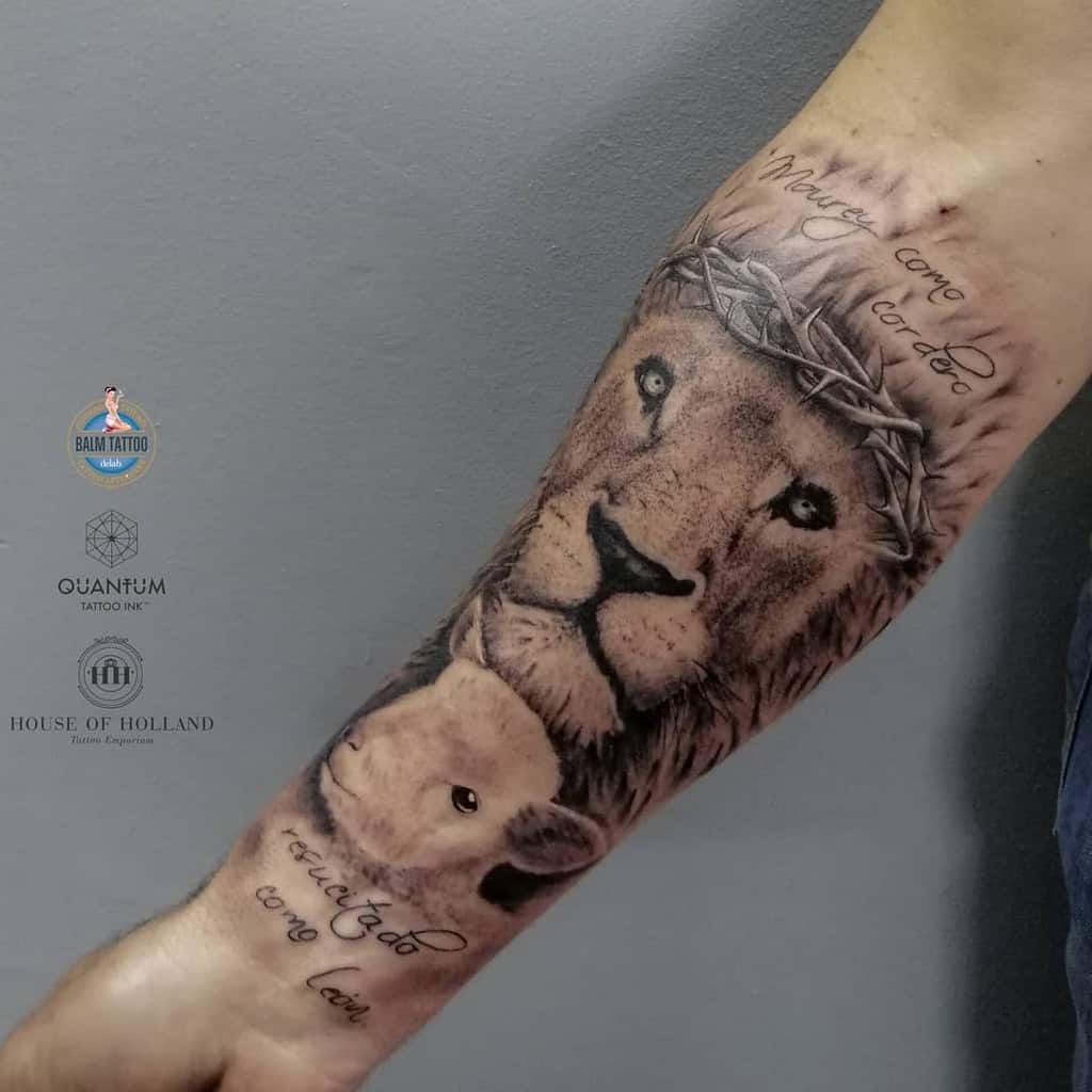 Tattoo of a lion and lamb on a forearm, with text above the lion's head and near the wrist