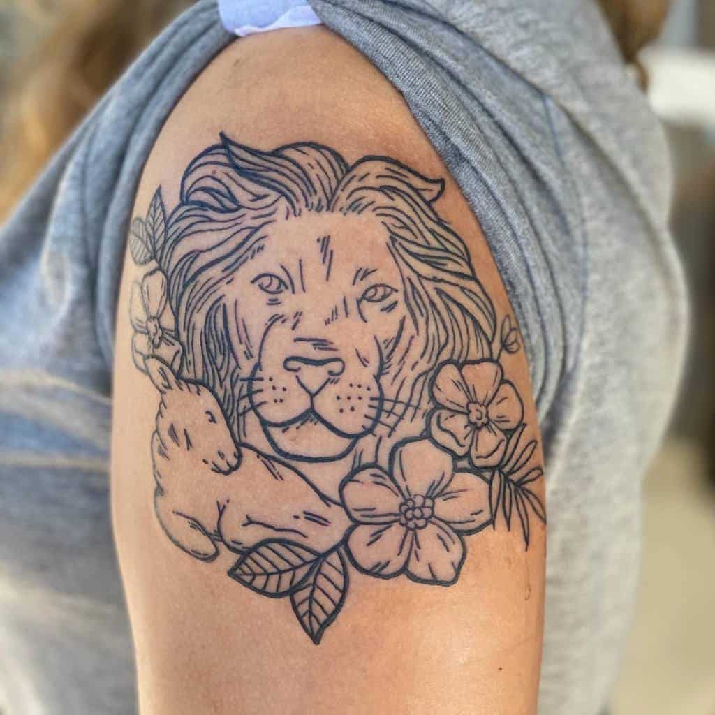Tattoo of a lion, lamb, rabbit, and flowers on an upper arm