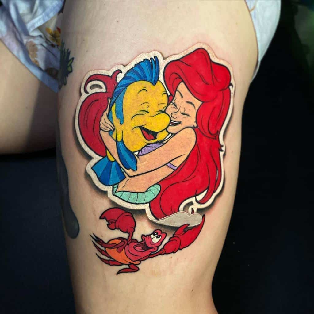 Colorful Ariel tattoo hugging Flounder with Sebastian below, capturing a joyful and playful underwater scene on the thigh
