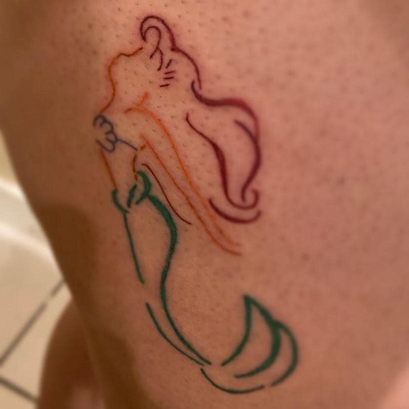 Minimalist outline tattoo of Ariel with colorful red, orange, and green accents, capturing her iconic silhouette in a simple design