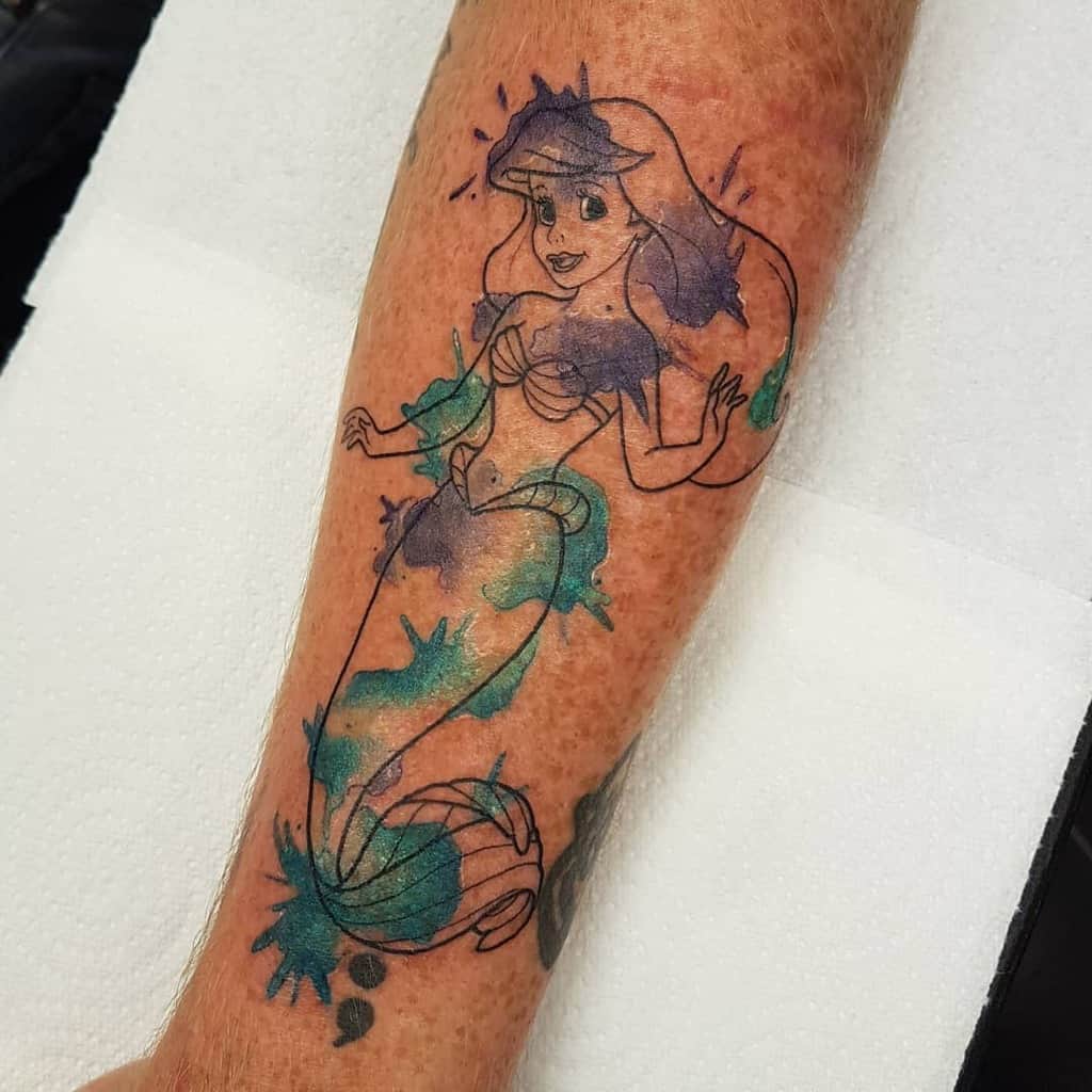 Playful Ariel tattoo with bold line art and splashes of watercolor in blue, green, and purple for a vibrant, artistic design