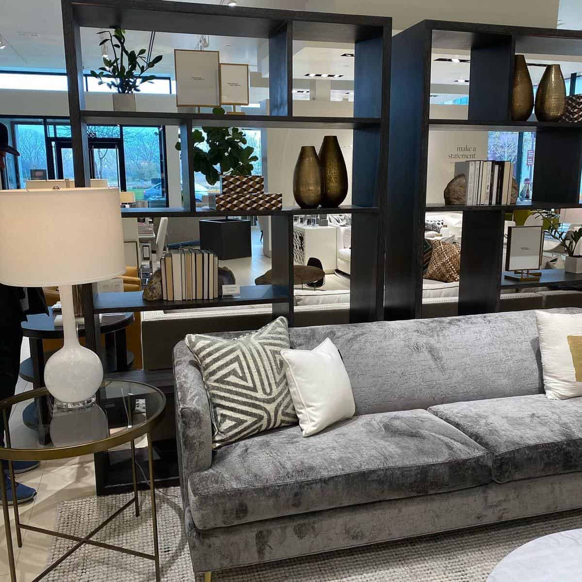 brown wood divider with shelves and gray couch