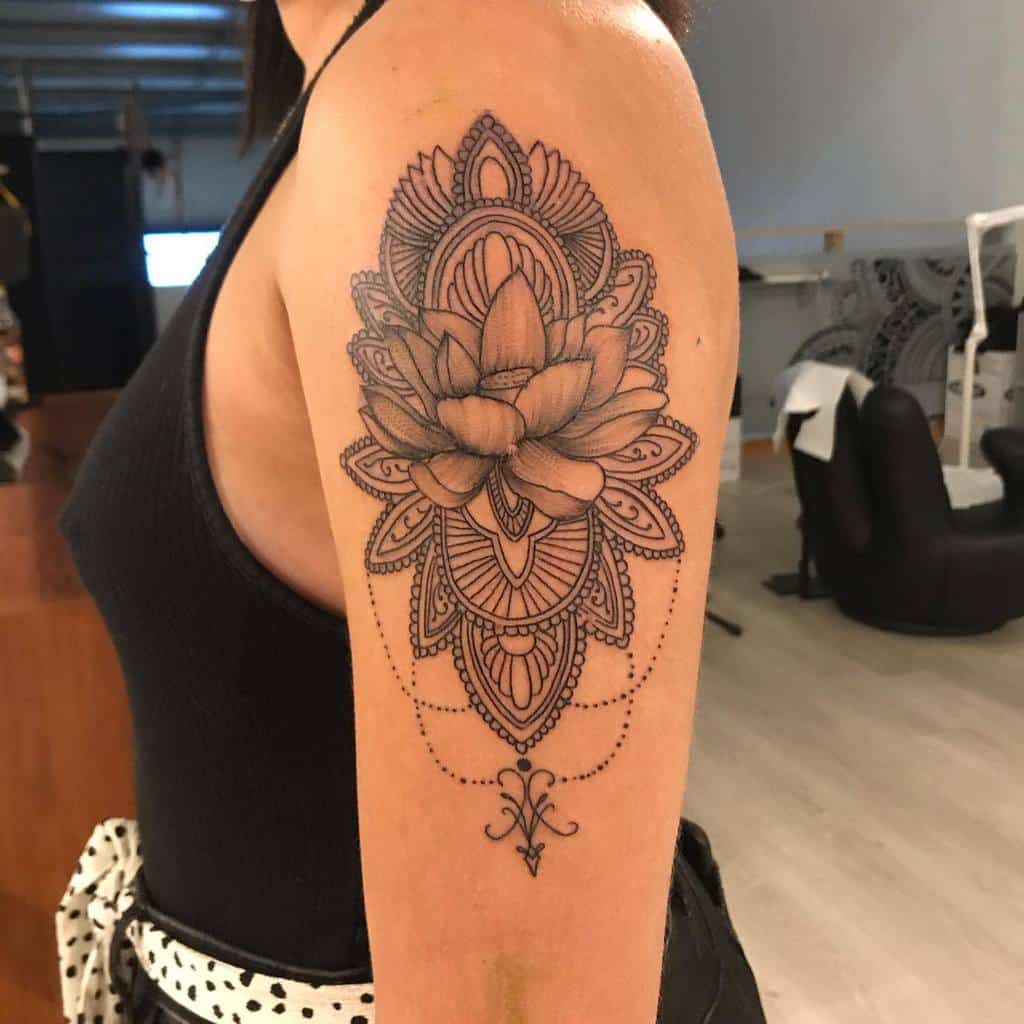 Arm tattoo featuring an intricate lotus flower design with detailed linework and patterns