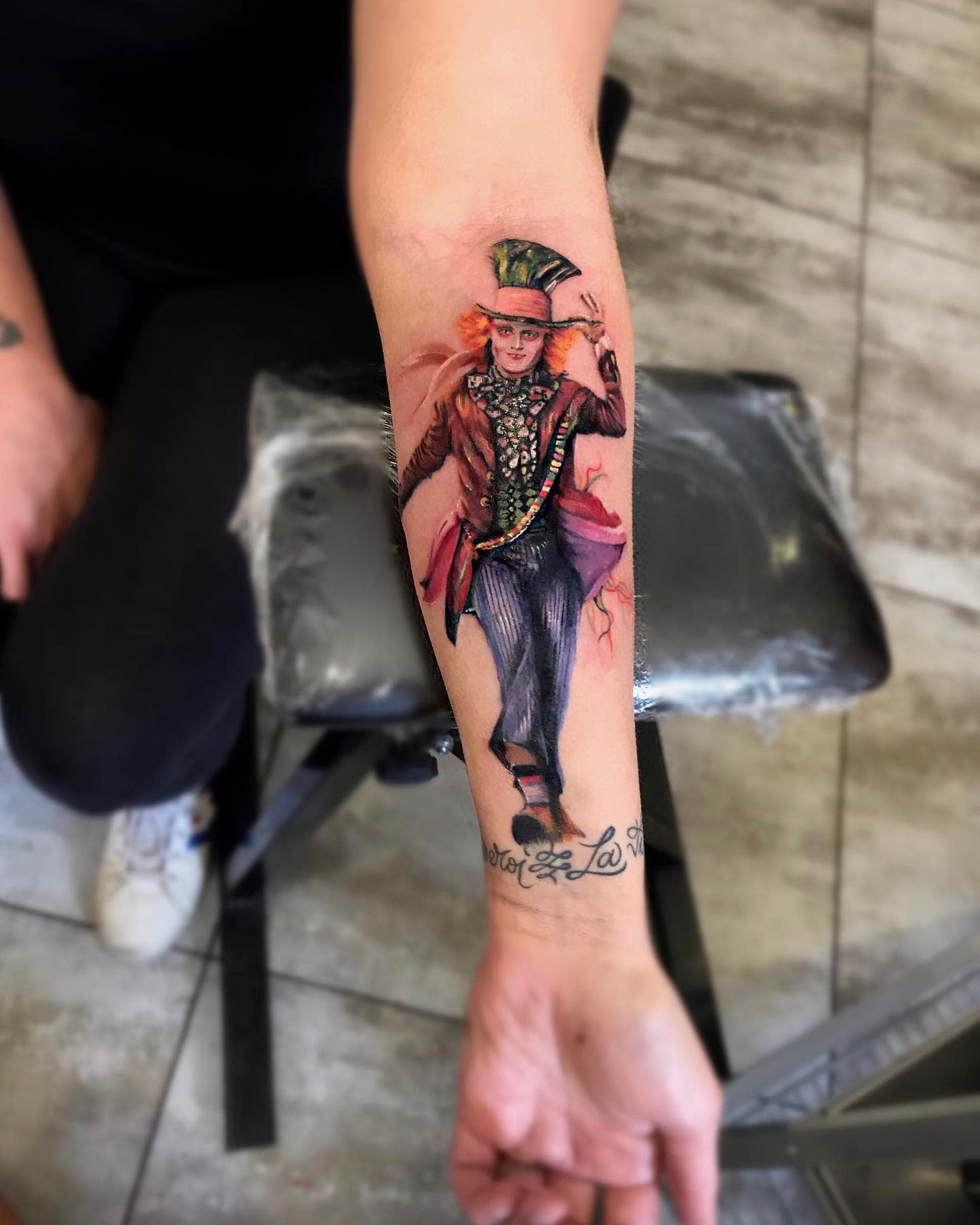 Realistic tattoo of the Mad Hatter mid-dance, capturing his vibrant energy and eccentric style on the forearm