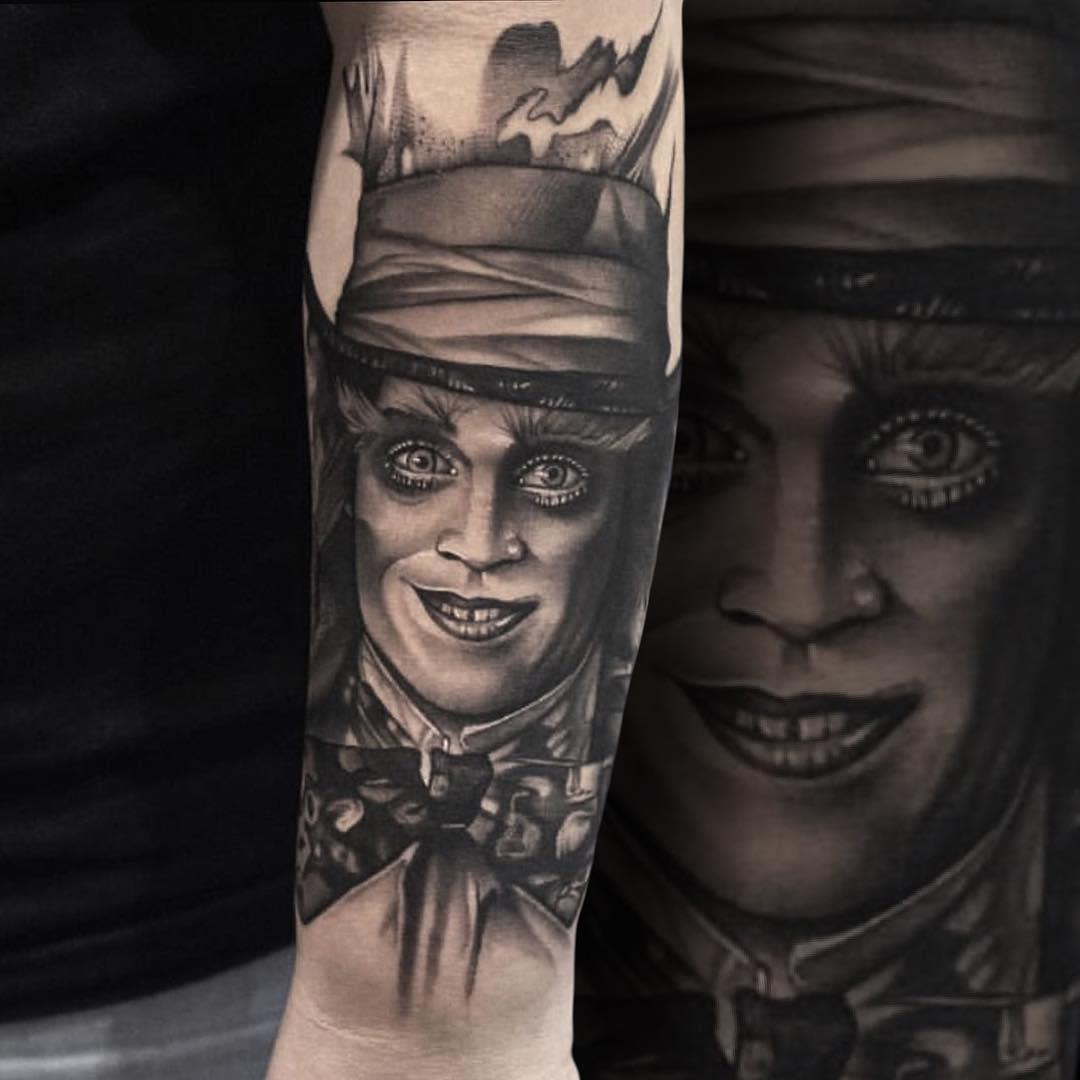 Realistic black and grey tattoo of the Mad Hatter with an intense gaze, capturing his eerie expression
