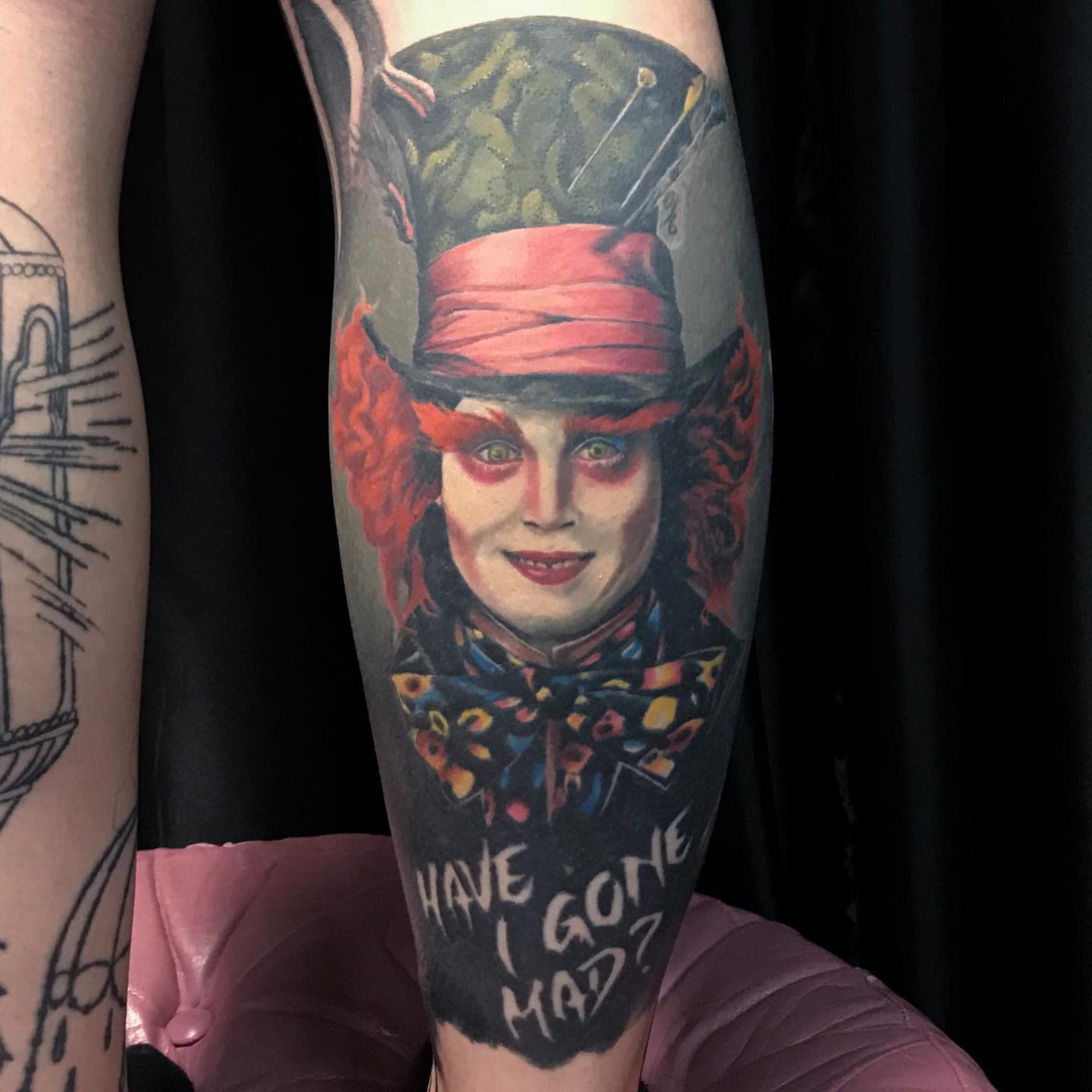 Colorful tattoo of the Mad Hatter with the quote 'Have I gone mad?' capturing his eccentric personality