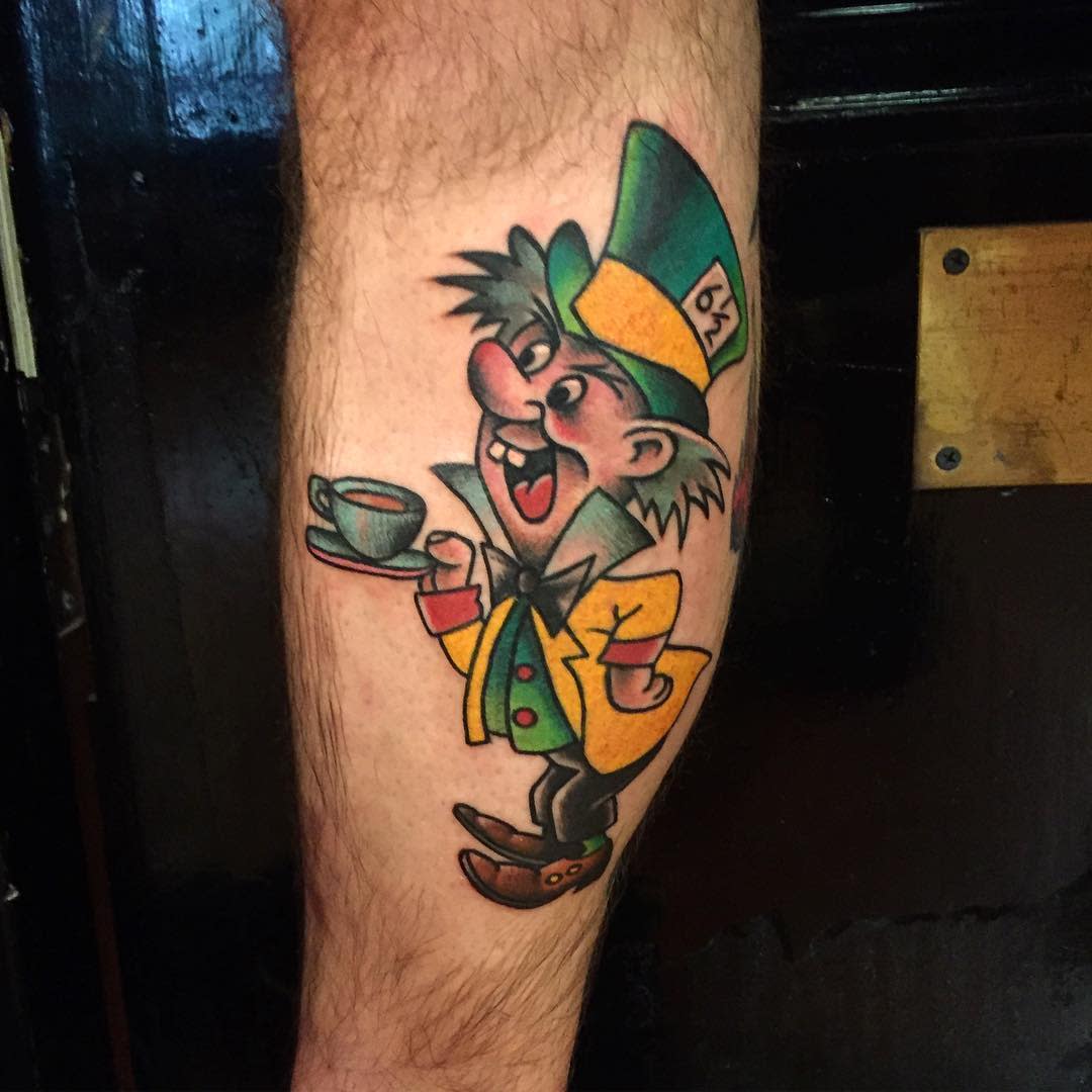 Traditional-style tattoo of the Mad Hatter holding a teacup, featuring bold colors and classic cartoonish design