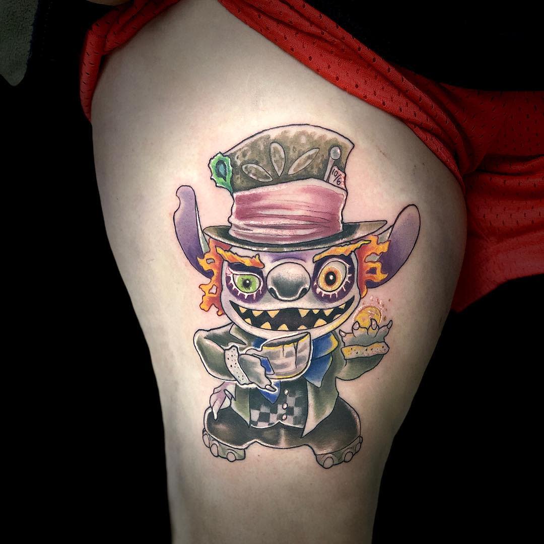 Playful tattoo of Stitch dressed as the Mad Hatter, combining elements of both characters in a vibrant, whimsical design