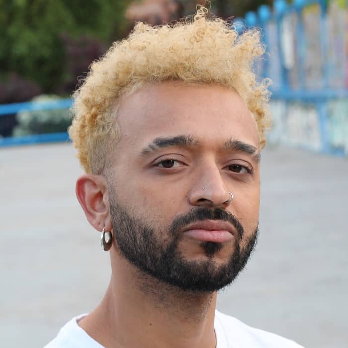 Man with blond highlights and dark facial hair