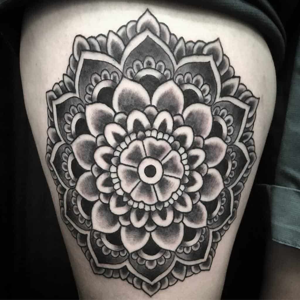 Black and gray mandala tattoo, featuring layered floral patterns with intricate shading and details