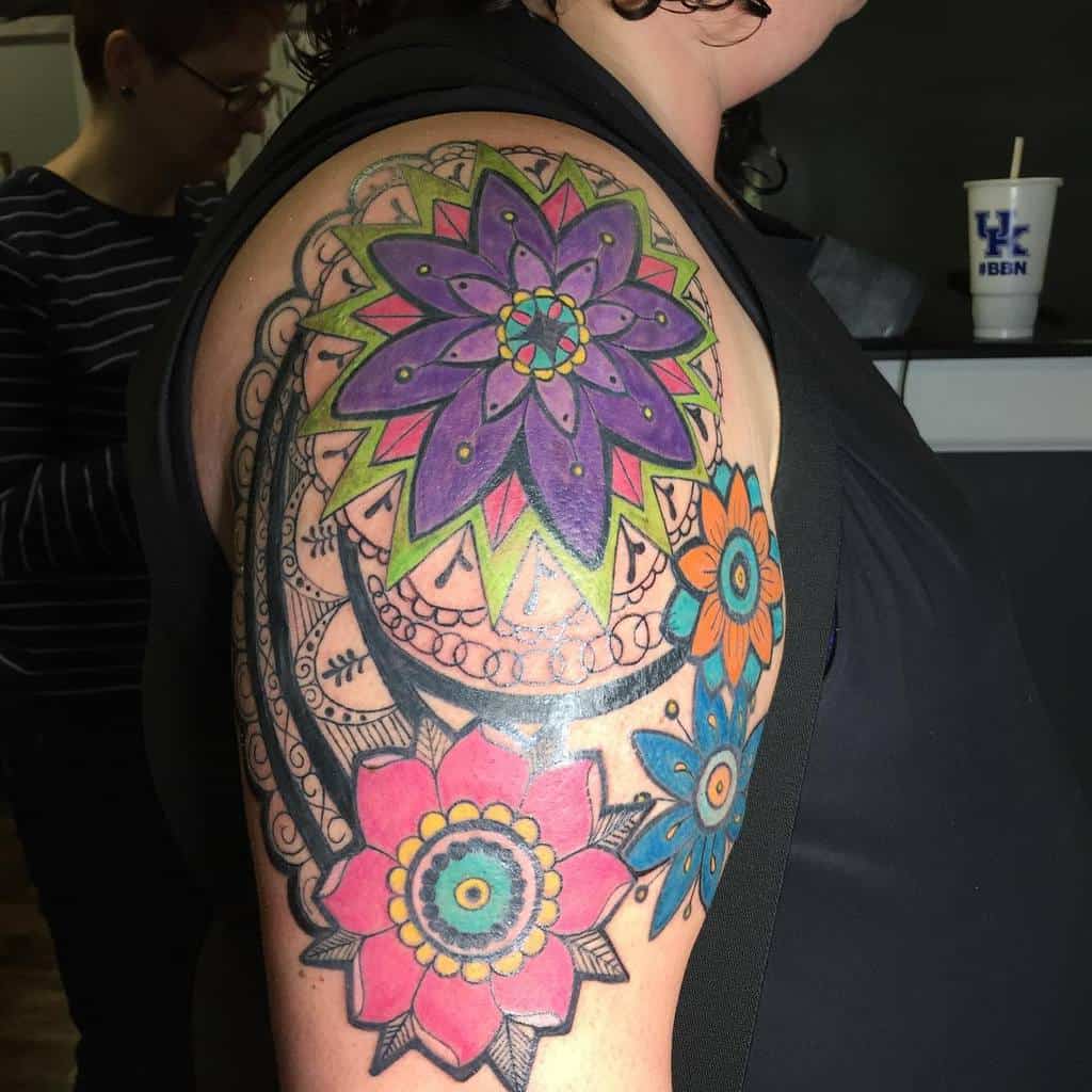 Colorful floral mandala tattoo on a person's arm with vibrant patterns and intricate designs