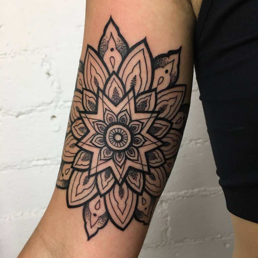 Ornate mandala tattoo with intricate patterns on an upper arm