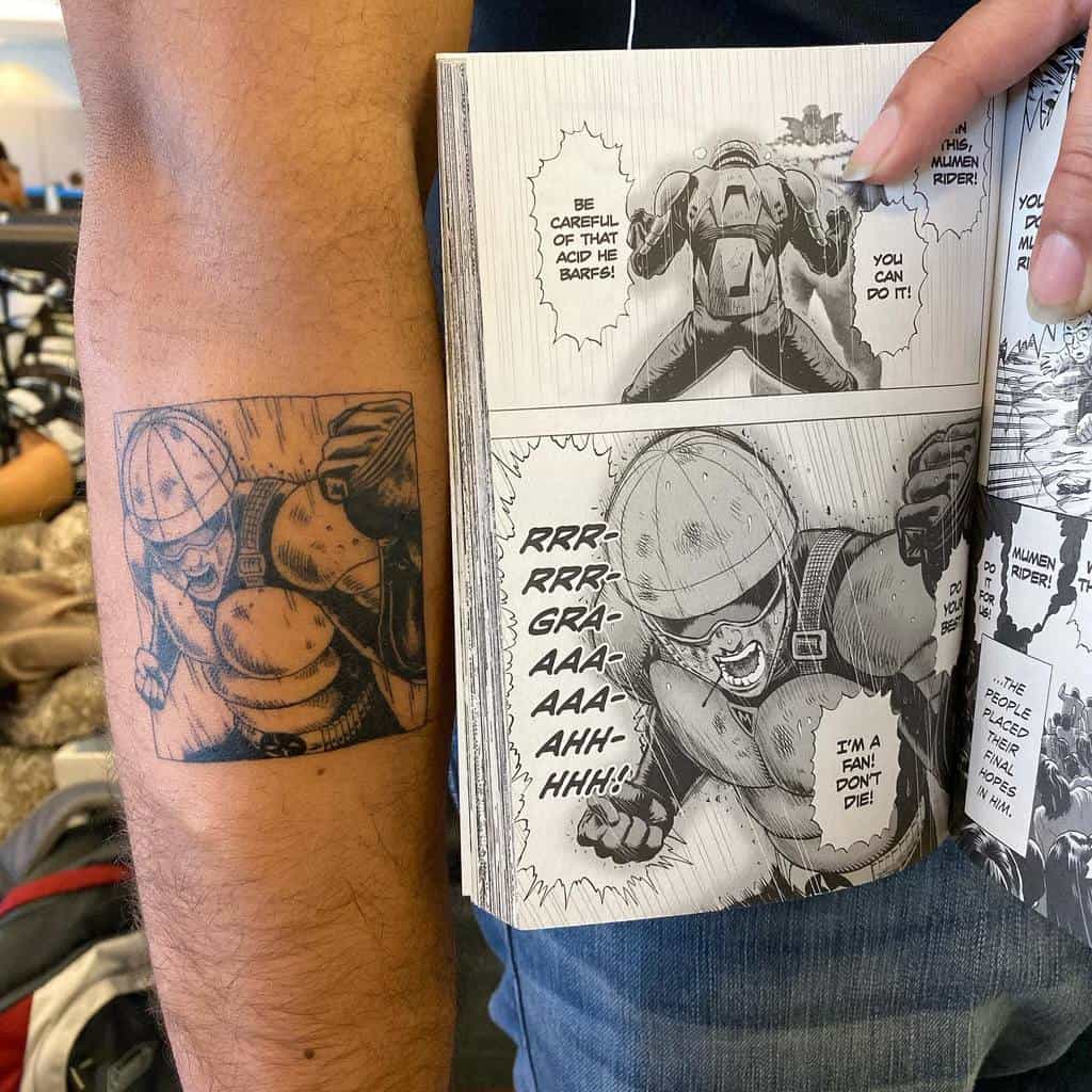 A black ink tattoo of Mumen Rider from One Punch Man, perfectly replicating a manga panel, shown alongside the original printed page