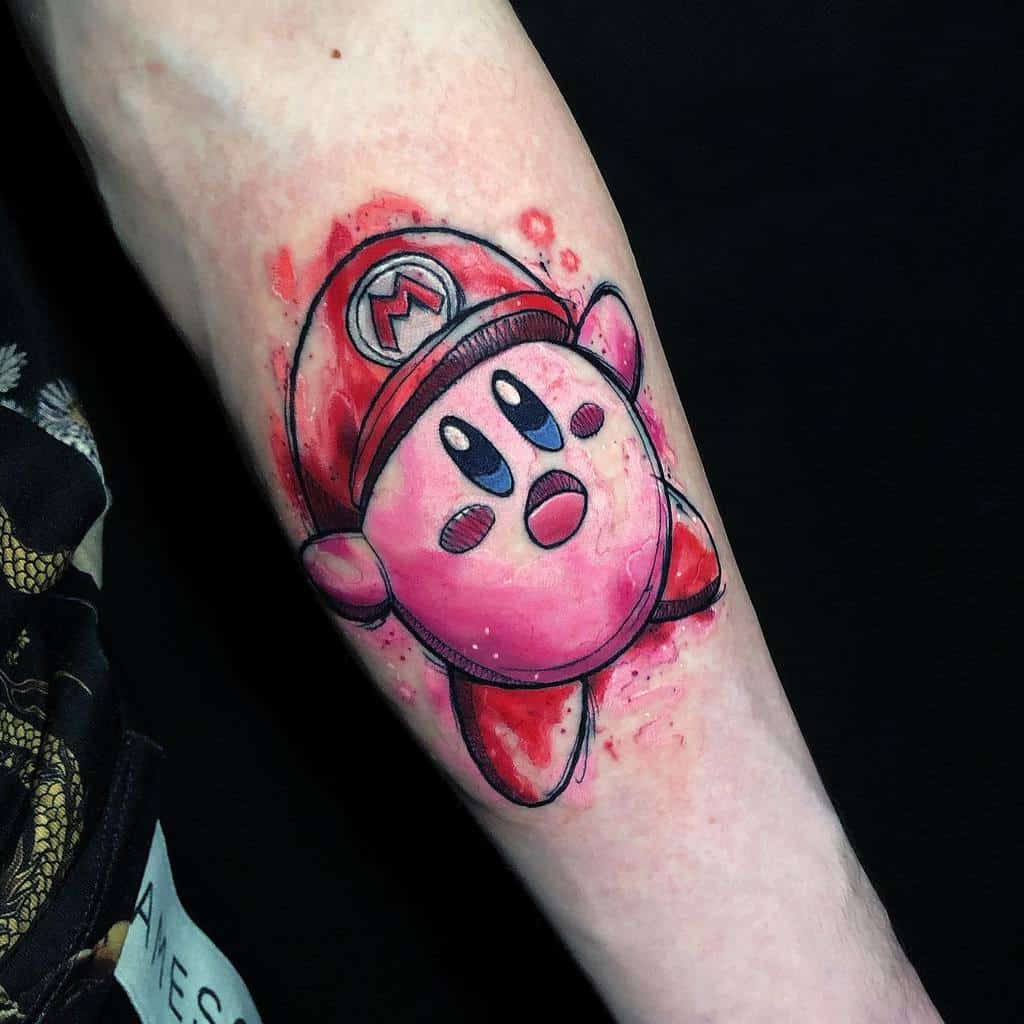 Kirby tattoo wearing Mario’s hat, done in a watercolor-style with red splashes