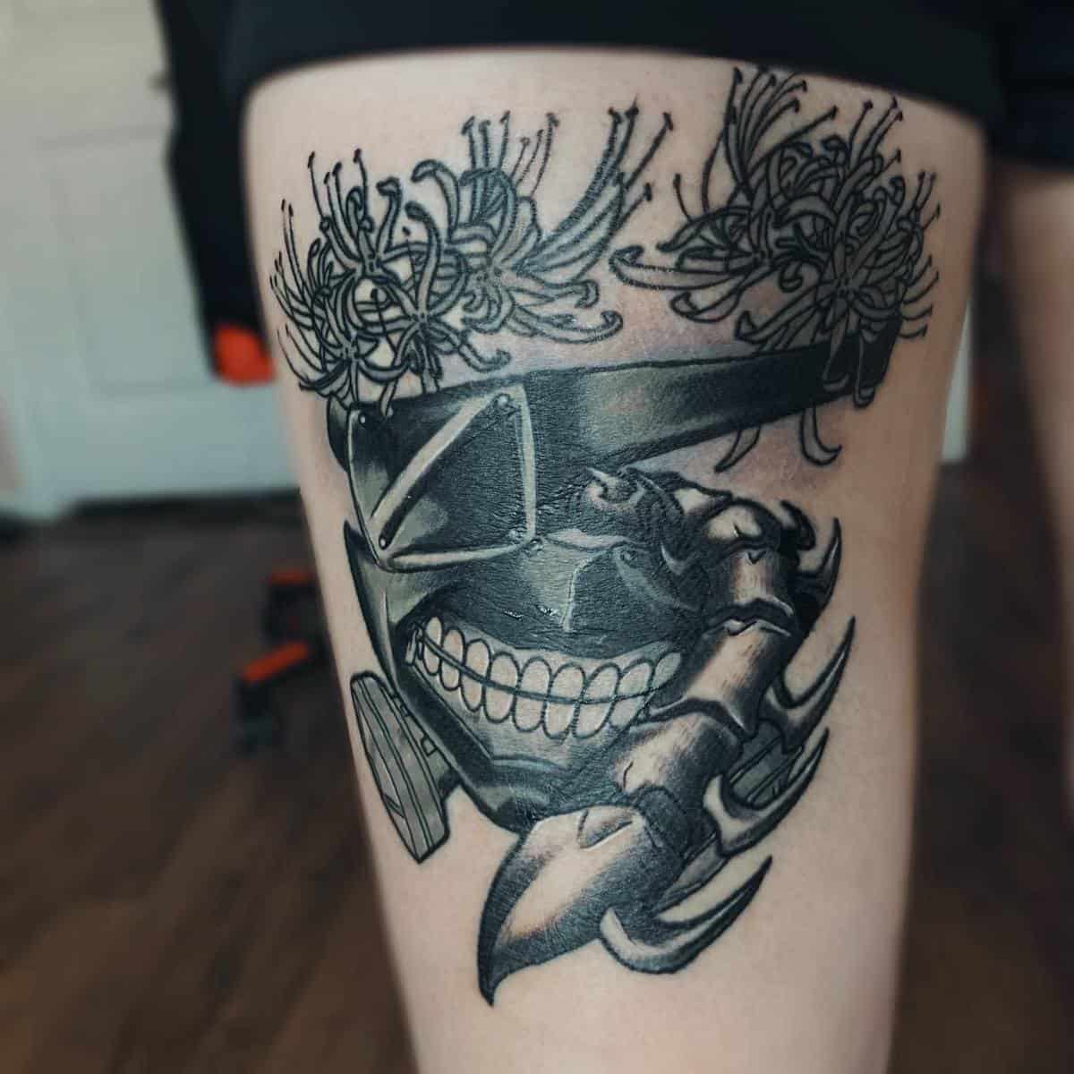 Thigh tattoo featuring Kaneki Ken's ghoul mask from Tokyo Ghoul, accented with detailed flowers and centipede elements