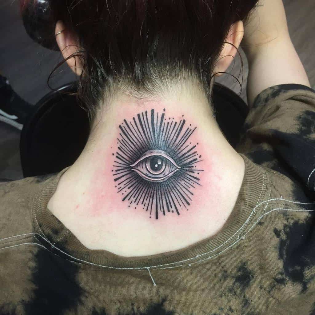 Tattoo of an eye with radiating lines on the back of the neck