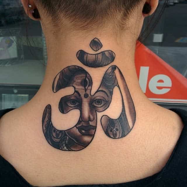 Tattoo of a face integrated into an Om symbol on the back of the neck