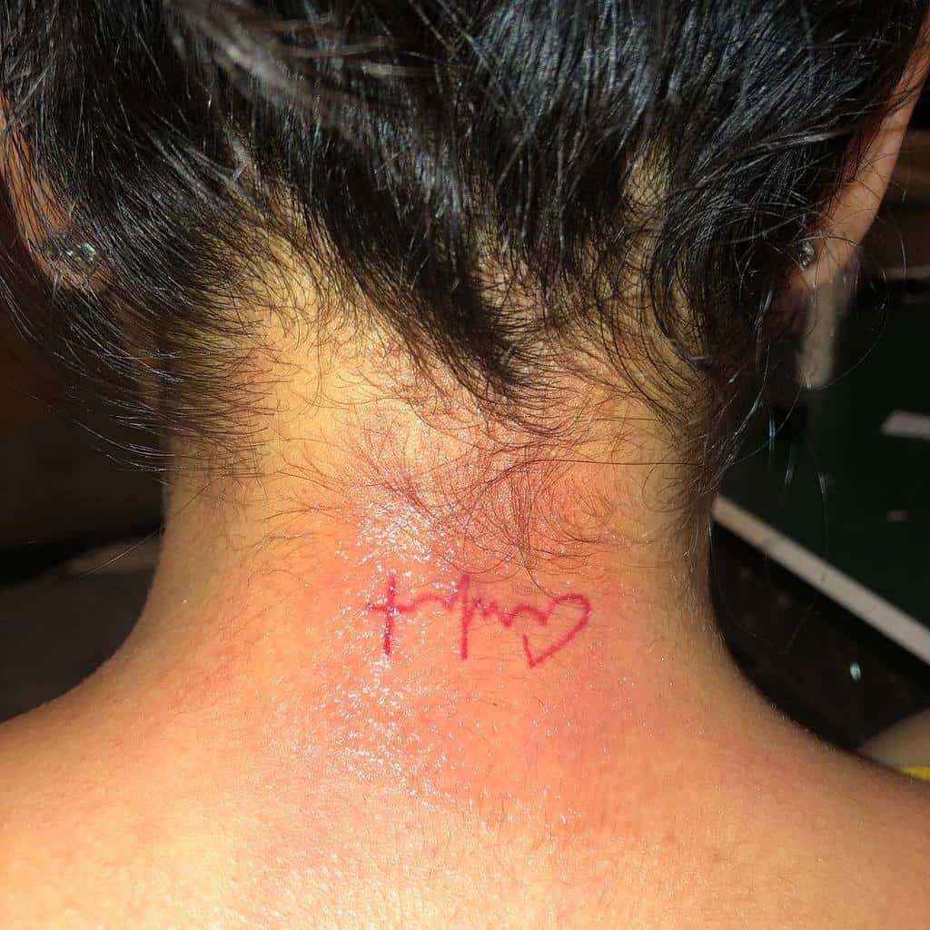 A red heart and heartbeat line tattoo elegantly inked on the back of neck