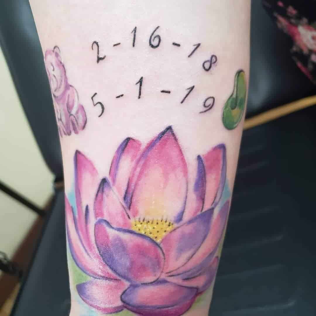 Tattoo of lotus flower, names, and dates "2-16-18" and "5-1-19" on an arm with bear and green bean icons