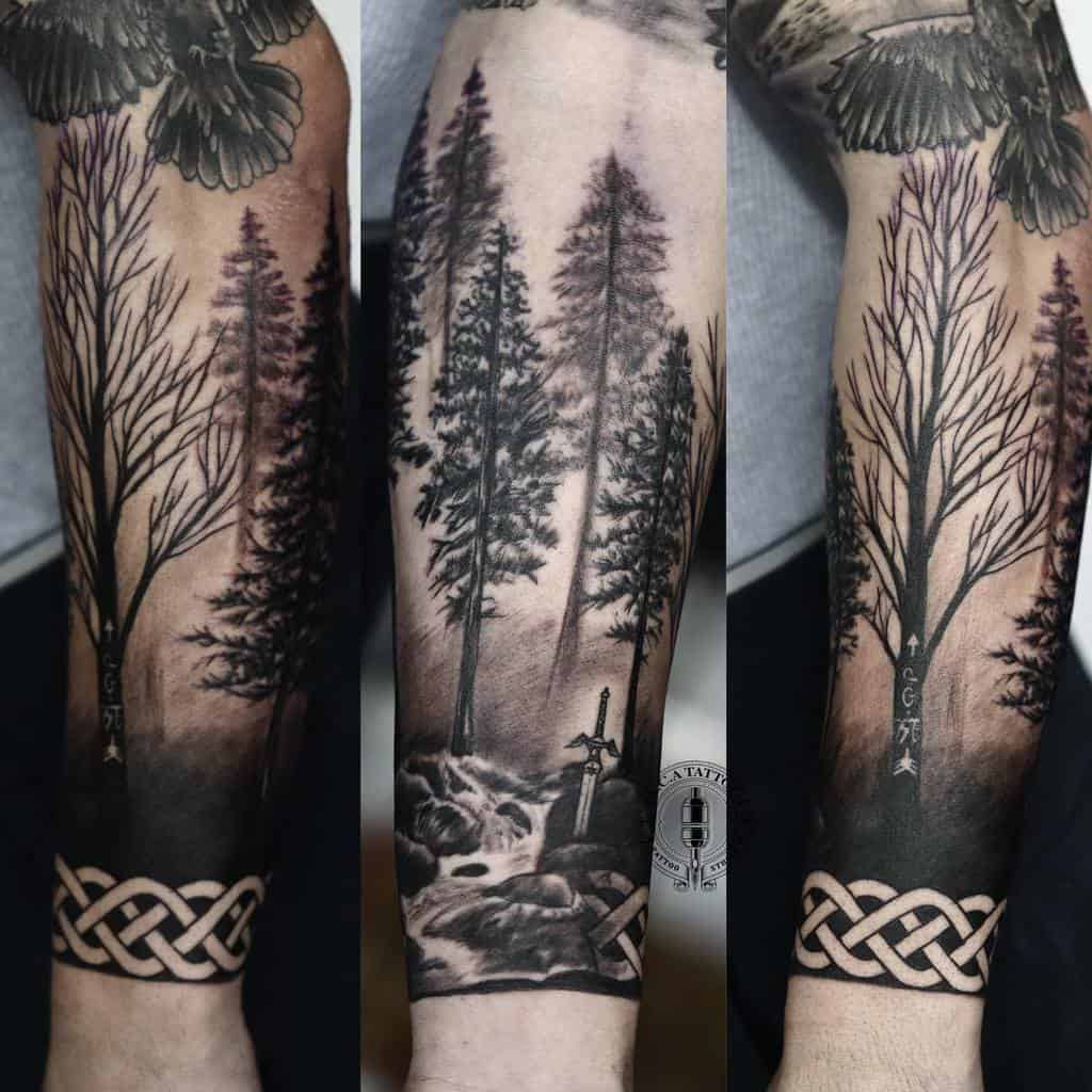Arm tattoo showcasing a forest scene with trees, a sword, and a Celtic knot design