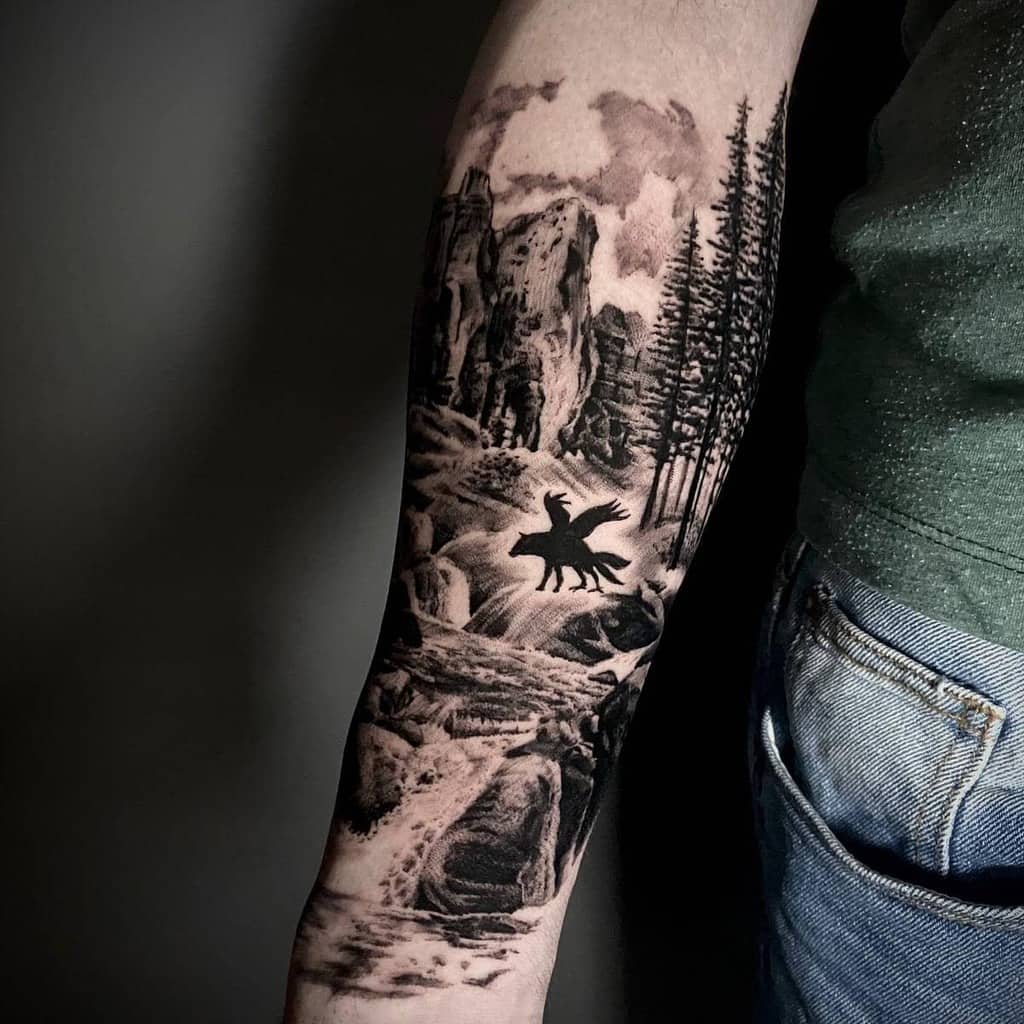 Half sleeve arm tattoo featuring a mountain landscape, trees, and a moose in silhouette