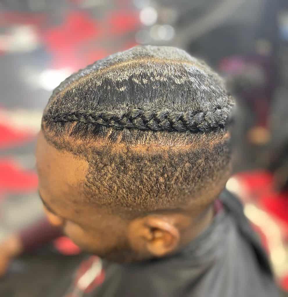 Men’s Cornrows Hairstyle Featuring Two Fine Braids On Top And Bold Detailing Cut Around The Temple